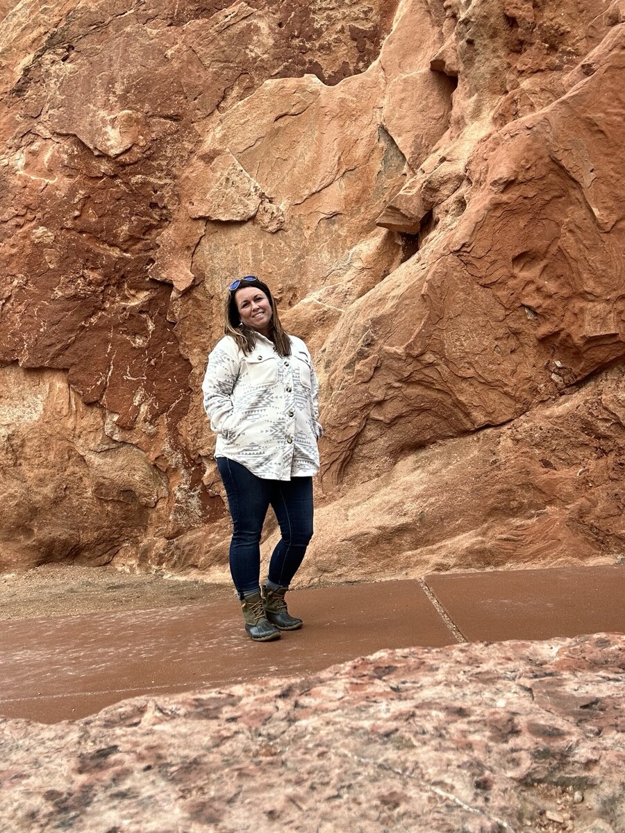 Jamie smiling among the red sandstone formations of Colorado